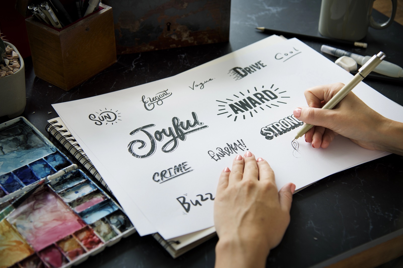 Artist drawing fonts for logos on paper